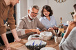 © Yakobchuk Olena - Senior bearded man smiling happily and looking at the dishes while making plates