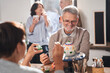 © Yakobchuk Olena - Two pensioners laughing while sitting at the table and decorating hand made teapots