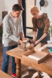 © Yakobchuk Olena - Female teacher showing to her senior client how to wrapping handmade plates at the paper