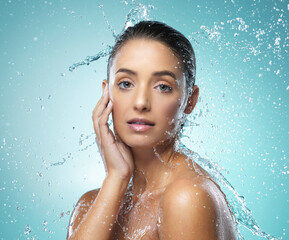 Canvas Print - Her skin is soft to the touch. Shot of a young woman taking a shower against a blue background.