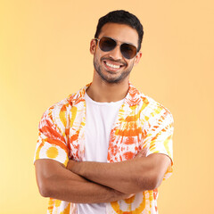 Its vacation time. Shot of a young man wearing glasses and a tie dye shirt while standing against a yellow background.