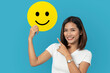 © suriya - Customer experience concept, cheerful young woman Raise a speech bubble with a smiley face. Critique her experience for a happy satisfaction survey.