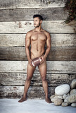 How could masculinity get more masculine. Full length shot of a handsome young man holding a football while posing nude.