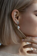 Luxurious woman with a short blond hairstyle and white pearl earrings, she is in profile with shiny fresh skin, close-up