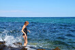 © Anna - teenage girl in a black swimsuit in the splashes of sea waves
