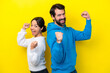 © luismolinero - Young caucasian couple isolated on yellow background celebrating a victory