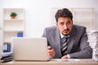© Elnur - Young male employee unhappy with excessive work in the office