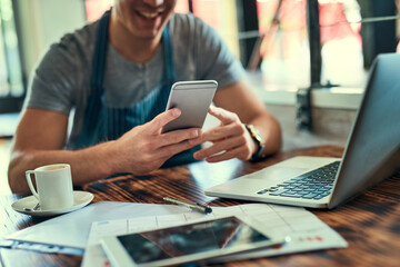 Poster - Trying to keep up with all these orders. Cropped shot of an unrecognizable man using on his cellphone in his coffee shop.