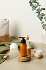 Wall Mural - Natural SPA cosmetic products set with eucalyptus leaves and green towel. Soap liquid dispenser bottle on wooden platform, glass dropper bottles, body brush, loofah. Eco beauty products.