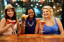 Having The Time Of Their Lives. Cropped Portrait Of Three Young Girlfriends Having Drinks At A Bar.
