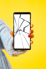 Poster - Big smartphone with broken screen. A woman holds a phone in her hand with cracks on the screen. The girl with the broken mobile phone. Smartphone repair.