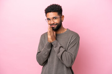 Wall Mural - Young Brazilian man isolated on pink background keeps palm together. Person asks for something