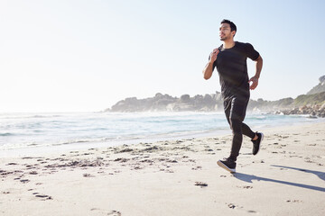 Canvas Print - One step in front of the other. Full length shot of a handsome young male athlete out for a run on the beach.