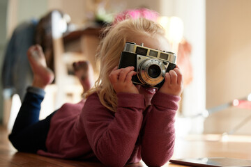 Canvas Print - Can I have a smile. Shot of a little girl taking a picture with a camera.