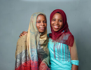 Wall Mural - Two happy African Nigerian female muslim sisters or friends with Hijab scarf, prepared to engage the process of prayer or ablution which is more noticeable during ramadan and when going to mosque