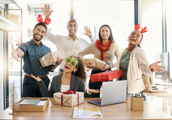 Poster - Sharing the Christmas spirit. Shot of a group of businesspeople celebrating during a Christmas party at work.