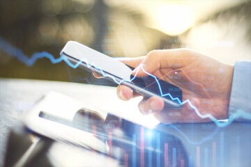 Poster - Close up of hand using smartphone with falling downword forex chart on blurry outside background. Crisis, stock and loss concept. Double exposure.