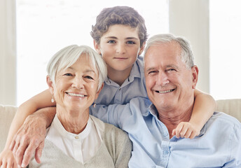 Wall Mural - He keeps us young. Shot of a mature couple bonding with their grandson on the sofa at home.