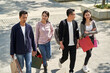 © imtmphoto - group of young asian people talking chatting conversing while walking on street with shopping bags