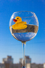 Rubber Yellow Duck With Big Red Lips Swims In A Large Glass Of Water Against A Blue Sky. Vacation And Travel Concept. Ukraine Flag Colors