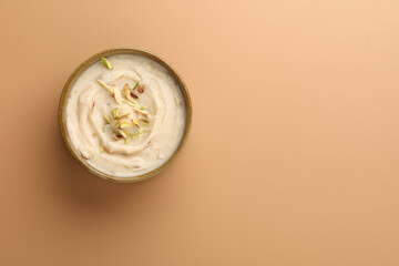 Wall Mural - Shrikhand is an Indian sweet dish made of strained curd,garnished with dry fruits and saffron. Served in a ceramic bowl.Selective focus