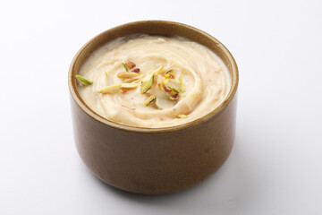 Wall Mural - Shrikhand is an Indian sweet dish made of strained curd,garnished with dry fruits and saffron. Served in a ceramic bowl.Selective focus