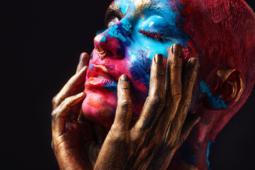 Im me and no one else. Shot of an attractive young woman posing alone in the studio with paint on her face.