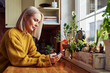 © baranq - Beautiful mature woman using smartphone in a kitchen