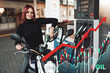 Portrait of female biker refueling her bike in gas station. Price increase of oil and fuel.
