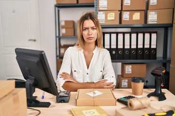 Poster - Young blonde woman working at small business ecommerce skeptic and nervous, frowning upset because of problem. negative person.