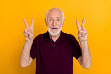 Poster - Photo of cheerful senior man show fingers peace victory v-symbol travel isolated over yellow color background