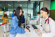 © shine - Beautiful young asian air hostess working at check in counter giving documents to tourist. Young asian woman plane boarding pass to staff on mobile phone. Website or Mobile Application Concept