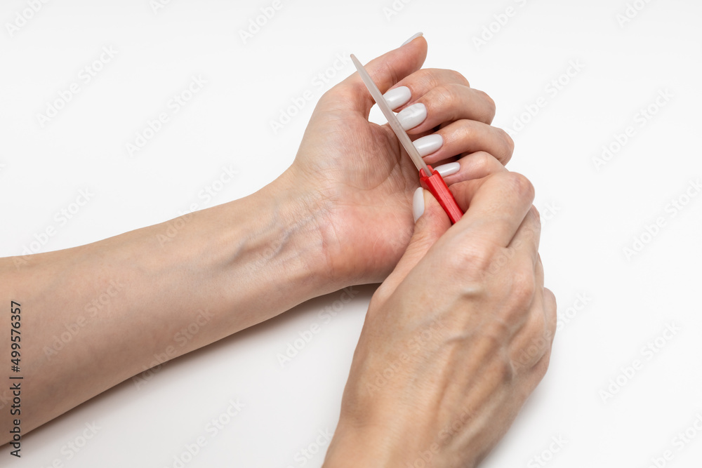 woman polishing her nails with a nail file