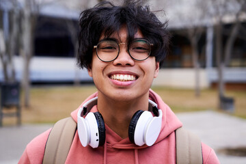 Close up shot of cheerful happy asian teenage boy looking at camera smiling. Intense look of a young man.