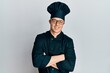 © Krakenimages.com - Handsome young man wearing professional cook uniform and hat happy face smiling with crossed arms looking at the camera. positive person.