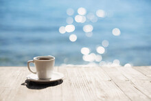 Coffee Cup On Wooden Table Over Beautiful Sea Background. Travel Background, Vacations, Summer Fun, Enjoying Life, Relaxation, Happiness, Lifestyle Concept.