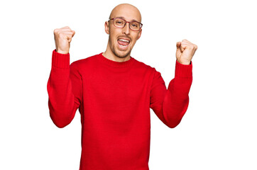 Bald man with beard wearing casual clothes and glasses screaming proud, celebrating victory and success very excited with raised arms