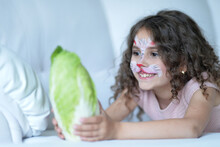 Cute Little Girl With Face Painted As Rabbit  With Cabbage