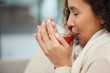 © Lumeez I/peopleimages.com - Detoxing. Cropped shot of an attractive young woman drinking a glass of herbal tea while sitting on a sofa at home.
