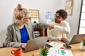 Canvas Print - Two business workers hitting fists at the office.