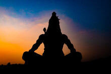 Back Lit Statue Of Hindu God Lord Shiva In Meditation Posture With Dramatic Sky From Unique Angle