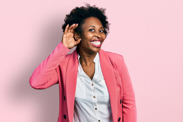 Canvas Print - African american woman with afro hair wearing business jacket smiling with hand over ear listening an hearing to rumor or gossip. deafness concept.