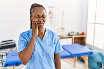 Canvas Print - Black woman with braids working at pain recovery clinic touching mouth with hand with painful expression because of toothache or dental illness on teeth. dentist