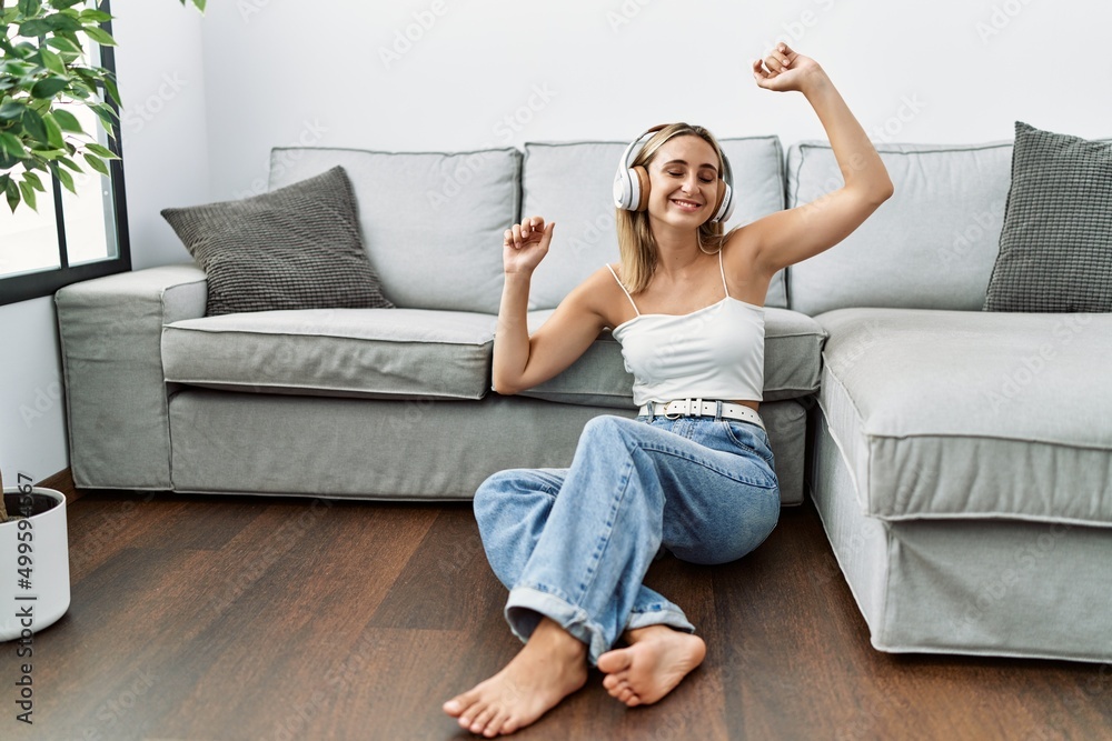 Young blonde woman smiling confident listening to music at home