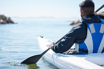 Poster - Open water is a highway to adventure. Rearview shot of a young man kayaking at a lake.