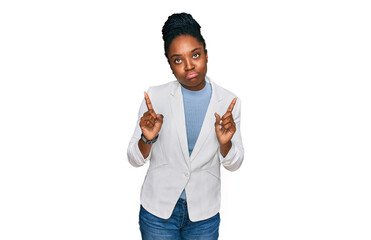 Poster - Young african american woman wearing business clothes pointing up looking sad and upset, indicating direction with fingers, unhappy and depressed.