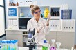 © Krakenimages.com - Young blonde woman wearing scientist uniform and gloves at laboratory
