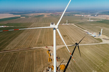 Canvas Print - Installing new wind generator, Windmill turbine maintenance, Construction site with cranes for assembling windmill tower, Wind power and renewable energy