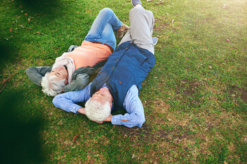 Sticker - Retirement is a time for reflection. Shot of a senior couple lying down on the grass and looking up at the sky.