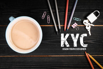 Wall Mural - KYC Know Your Customer. Coffee mug, pencils and padlock on a wooden background